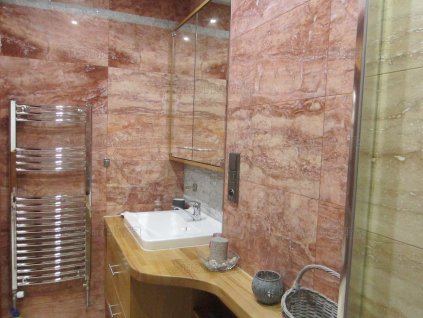 Bathroom with mirror and reddish travertine cladding – Travertine Red VC, filled and polished