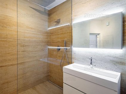 Bright bathroom with shower and vanity clad in Travertine Classic Light VC, unfilled and brushed large-format tiles.
