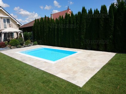 Pool deck pavers — Travertine Light French pattern around the poolside in a backyard setting.