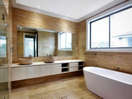Modern bathroom clad in warm beige natural stone – Travertine Gold VC, filled and honed.