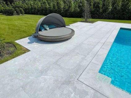 Poolside terrace with light non-slip natural stone surface – Marble Dolphin, sandblasted large-format tiles.