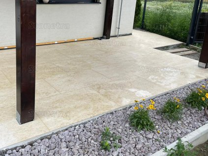 Covered patio with warm beige natural stone flooring – Marble Shells Beige, honed large-format tiles.