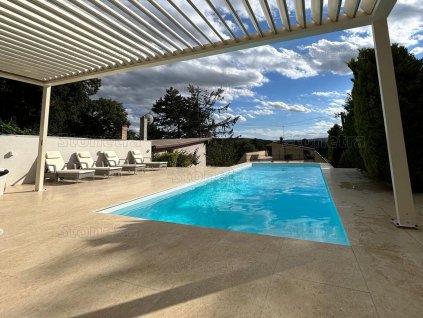 Pergola area by the swimming pool paved with beige natural stone – Marble Shells Beige, honed large-format tiles.
