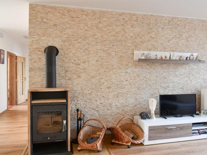 Living room feature wall clad with natural stone Travertine Classic mosaic, 2.5×5 cm split face.
