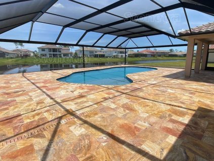 Outdoor pavers in Travertine Peach French pattern 3 cm surrounding the pool on a spacious patio.
