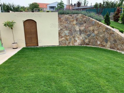 Retaining cellar wall finished with rusty-toned irregular stone — Andesite Rusty 15–40 cm, 1–3 cm thickness for façade cladding.
