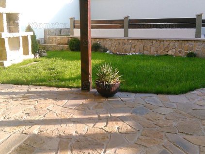 Sunny terrace paved with warm irregular natural stone — Sandstone 15–50 cm, 2–5 cm thickness for patios and paths.