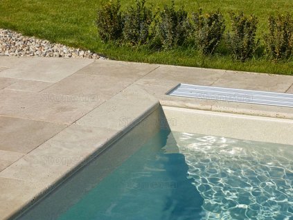 Pool edge finished with non-slip natural stone coping — Travertine Classic, tumbled 80×25×3 cm.