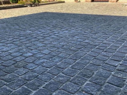 Square-pattern field of Granite Black cobblestones 6–8 cm — robust natural-stone paving for courtyards and streets.