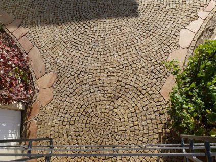 Fan-pattern pavement made from Sandstone Yellow cobblestones 4–6 cm — warm natural-stone setts with textured surface.