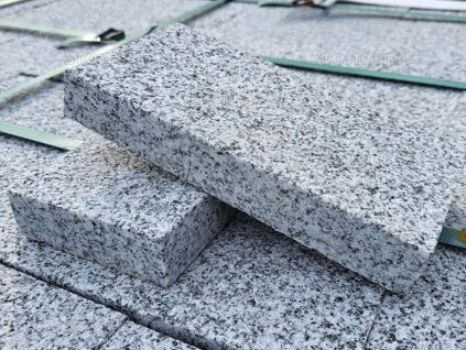 Stack of Rammer Grey granite pavers 20×10×3 cm — sawn edges with uniform sandblasted surface.