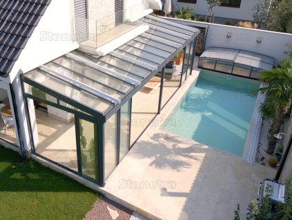 Garden patio slabs in Marble Saturn, sun-lounger deck beside the pool with clean edges.