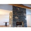 Stone accent wall Gneis Blue-Green Mond around fireplace adding natural contrast with blue-green slate look.
