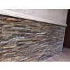 Stone siding Gneis Brown Mond used on house base wall highlighting rough split face texture.