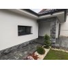 Stone siding Slate Grey used on lower part of house wall with white plaster and garden detail.