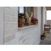 Travertine stone bricks Classic arranged around exterior window with smooth horizontal joints.