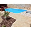 Pool deck pavers from Travertine Classic around a modern backyard pool, clean edges.