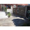 Small courtyard paved with Travertine Silver beside a stone fence.