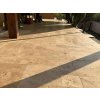 Natural stone tiles Travertine Classic French pattern creating a smooth patio surface in front of the house.