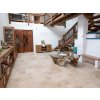 Indoor stone tiles in Travertine Light French pattern installed across a bright living room with timber furnishings.