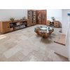 Natural stone tiles in Travertine Light French pattern laid through a spacious lounge area.