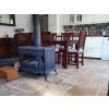 Indoor stone tiles — Travertine Noche French pattern — used through a dining area with a stove.
