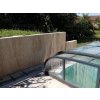Stone wall tiles Travertine Classic VC surround a private pool area with elegant beige travertine cladding.