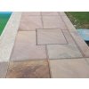 Outdoor pavers in Sandstone Modak show a neat surface with a utility hatch near the pool terrace.