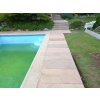 Stone walkway pavers in Sandstone Modak guide a narrow path beside the pool and lawn.