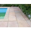 Garden patio slabs in Sandstone Modak cover the poolside terrace area.