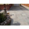 Paving slabs in Sandstone Greyl Roman pattern define a practical patio space by the house.