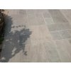 Paving slabs in Sandstone Greyl Roman pattern are shown in a clean surface detail on a modern patio.