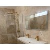 Natural stone tiles Marble Light Emperador with polished finish give shower areas a luxurious marble texture.