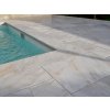 Pool pavers marble Alexandria French pattern surrounding a modern backyard swimming pool with light stone finish.