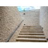 Exterior stone cladding Travertine Classic covers the staircase walls with natural beige travertine panels.