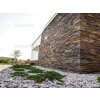 Stone facade cladding Slate Skalitz enhances the exterior of a house with dark layered slate.