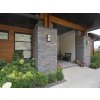 Rock siding Sandstone Torm rock face cladding highlights a modern house entrance with grey-brown sandstone.