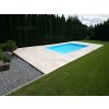 Pool pavers with Travertine Light French pattern framing a swimming pool and lawn, wide shot.