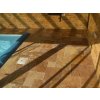 Pool deck pavers in Travertine Gold French pattern beside the pool with channel drain detail.