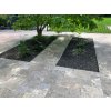 Outdoor pavers in Travertine Silver French pattern on a spacious terrace next to lawn and trees — overall view.