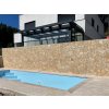 Poolside retaining wall finished with tumbled irregular limestone — Limestone Antik 15–50 cm, 2–3 cm natural stone cladding.