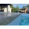 Pool pavers from Travertine Classic forming the coping edge, close view of the waterline and chamfered perimeter detail.