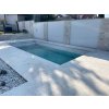 Pool pavers of Travertine Light — safe, non-slip surround and steps by the residential pool.