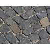 Close-up of small-format black basalt cobblestones laid with gravel joints - durable natural-stone paving.