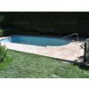 Pool deck pavers with Travertine Noche around a backyard swimming pool, clean edging and light-beige stone surface.