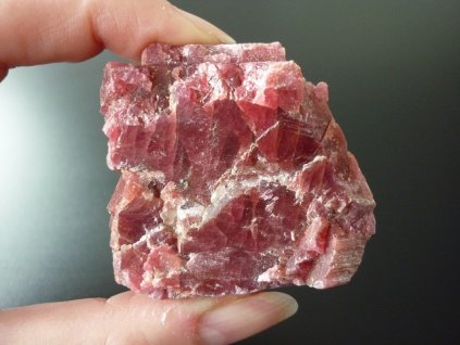 rodonit minerál držený v prstech přední strana