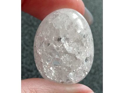 křišťál pukaný držený v prstech detail