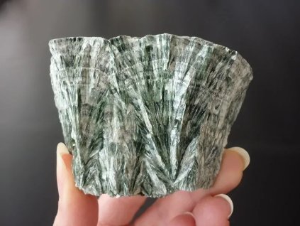 serafinit minerál držený v prstech přední strana