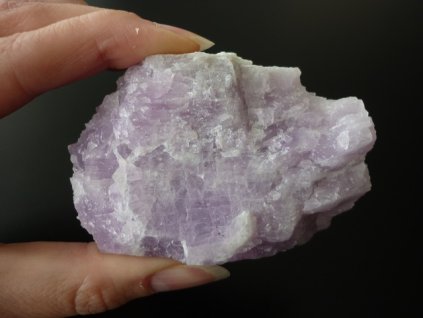 surový kunzit minerál držený v prstech