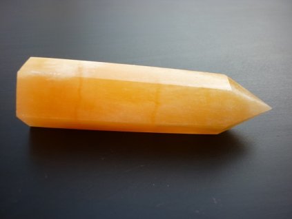 kalcitový minerální hrot položený na stole